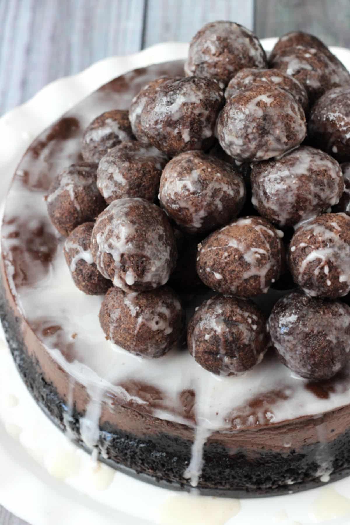 Top view of a chocolate donut hole cheesecake piled high with donut holes.