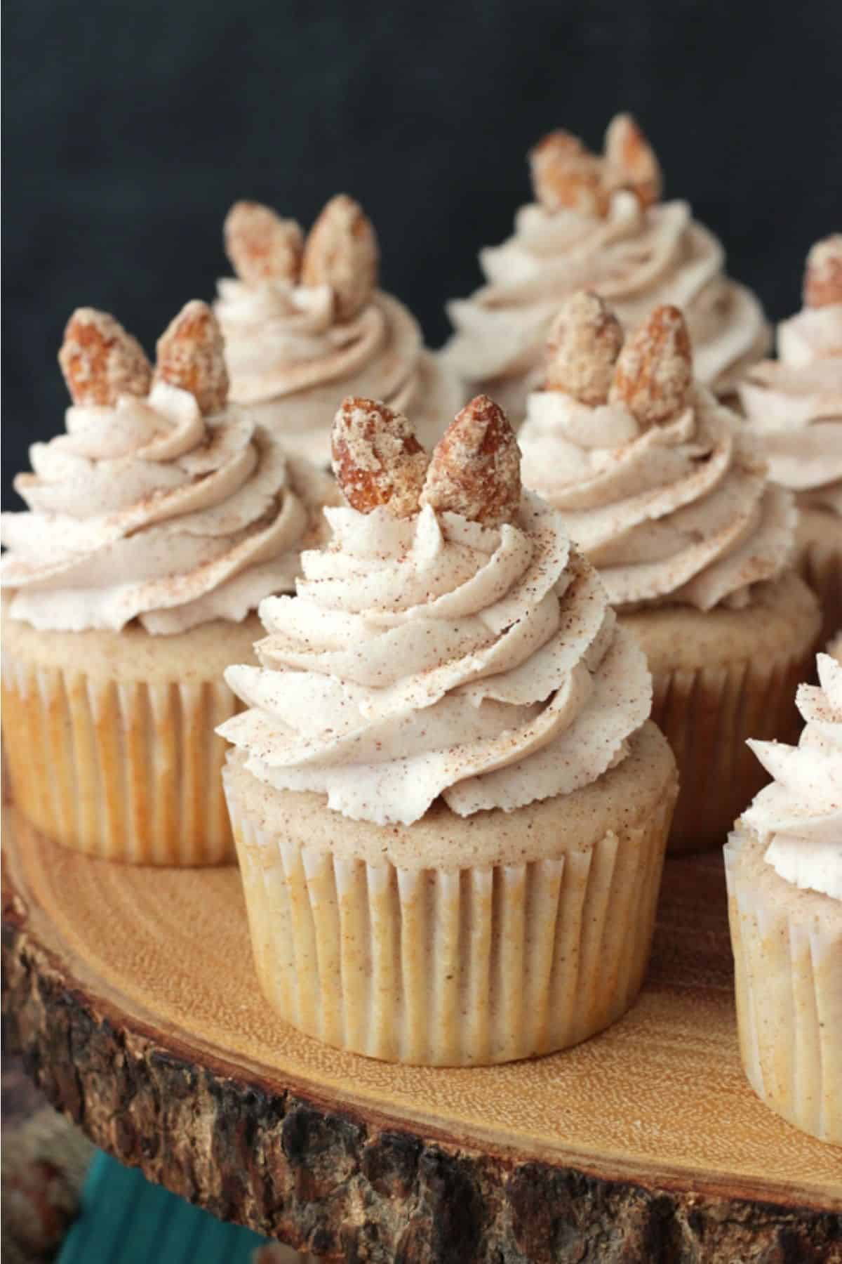 Close up of cinnamon sugar almond cupcakes on a wooden cake stand.