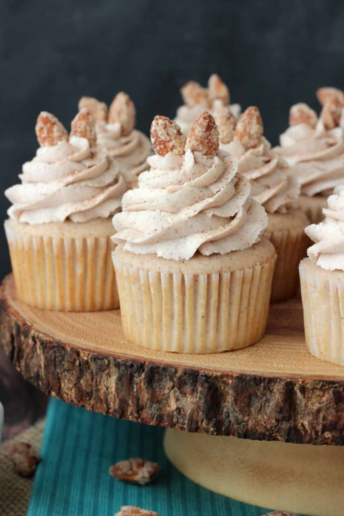 Close up of cinnamon sugar almond cupcakes on a wooden cake stand.