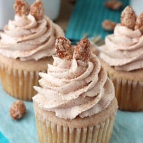 Close up of 3 cinnamon sugar almond cupcakes on a teal napkin.