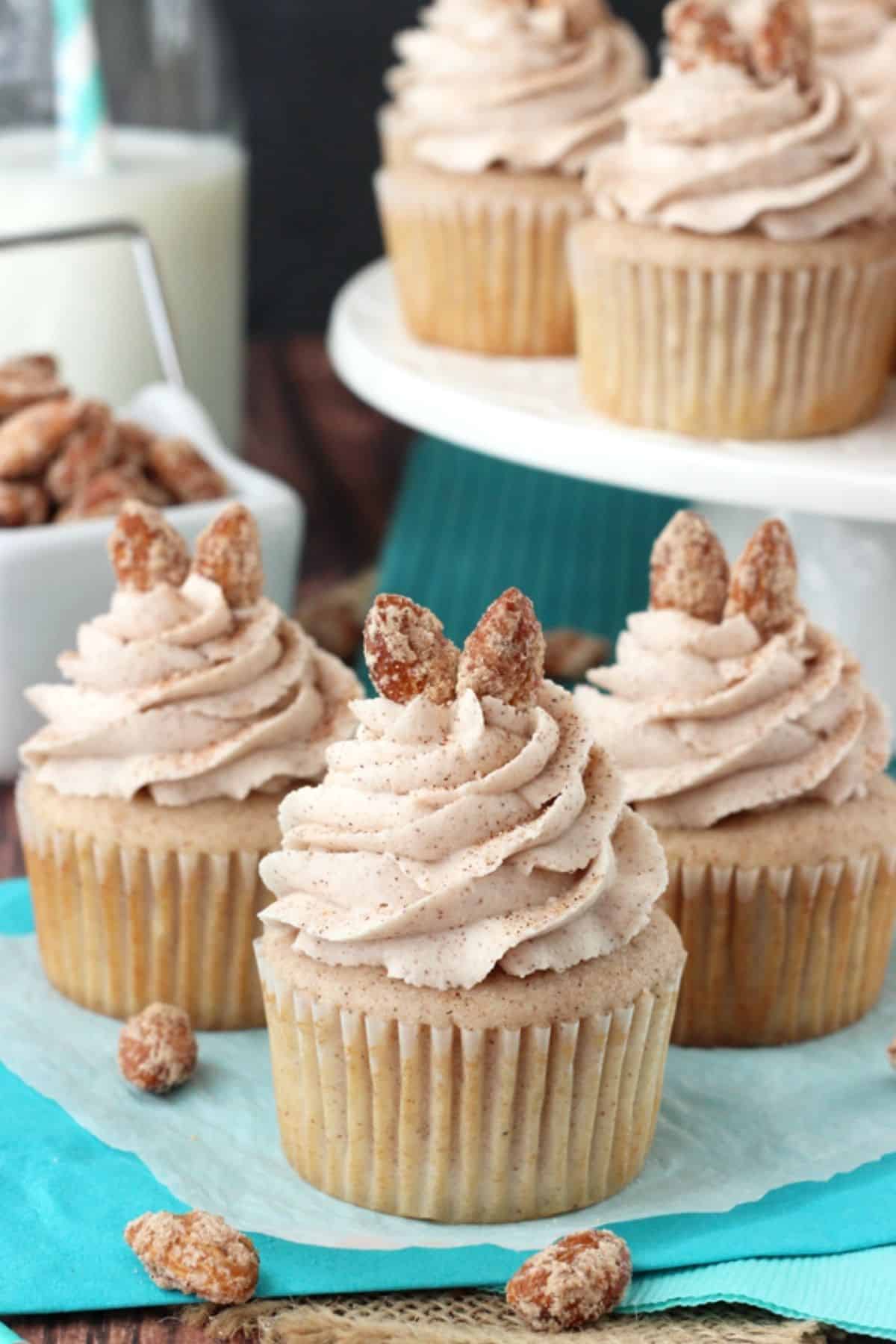 Close up of three cinnamon sugar almond cupcakes with more cupcakes in the background.