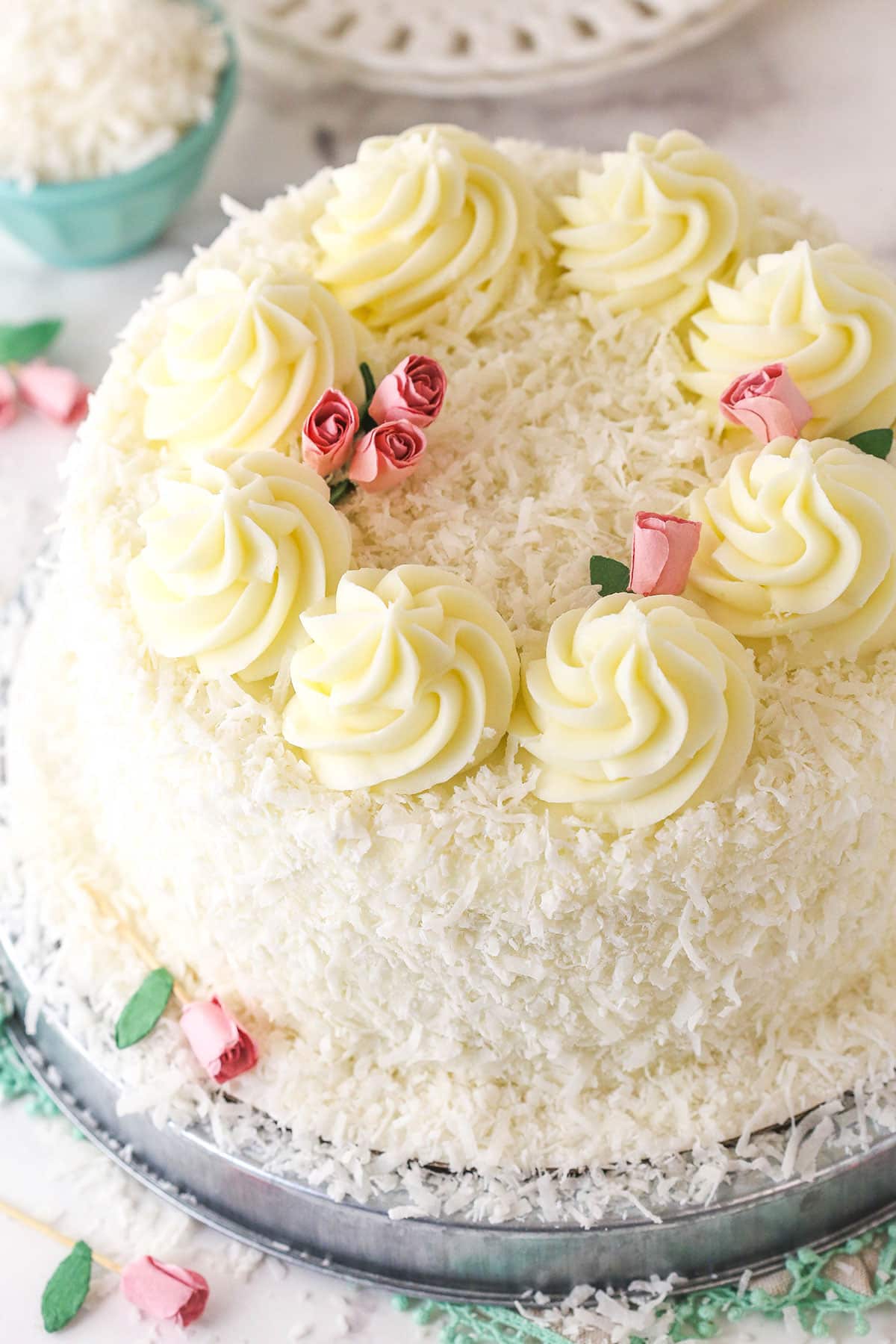 finished coconut cake on metal platter, view from angle above