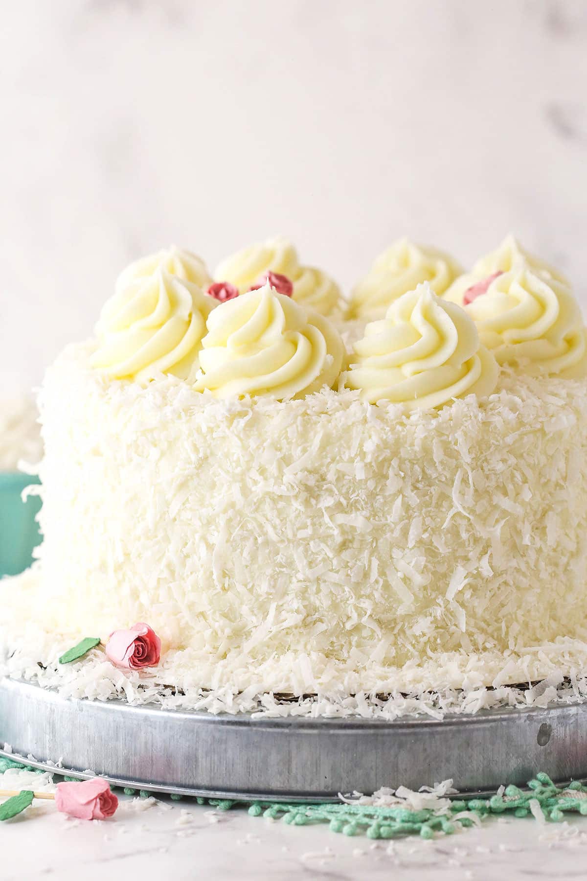 side view of coconut cake on metal platter