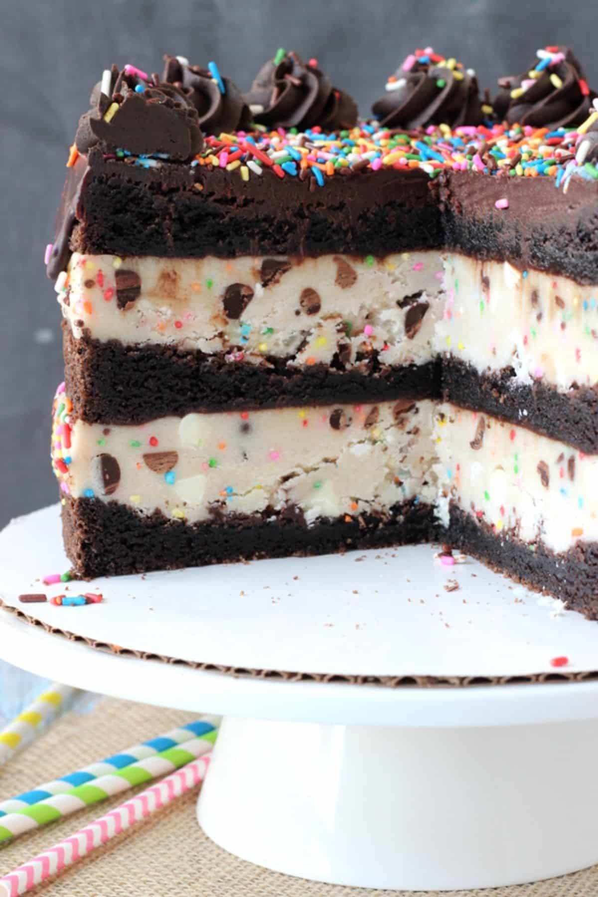 Close up of a cookie dough brownie layer cake with a few slices removed to show layers.