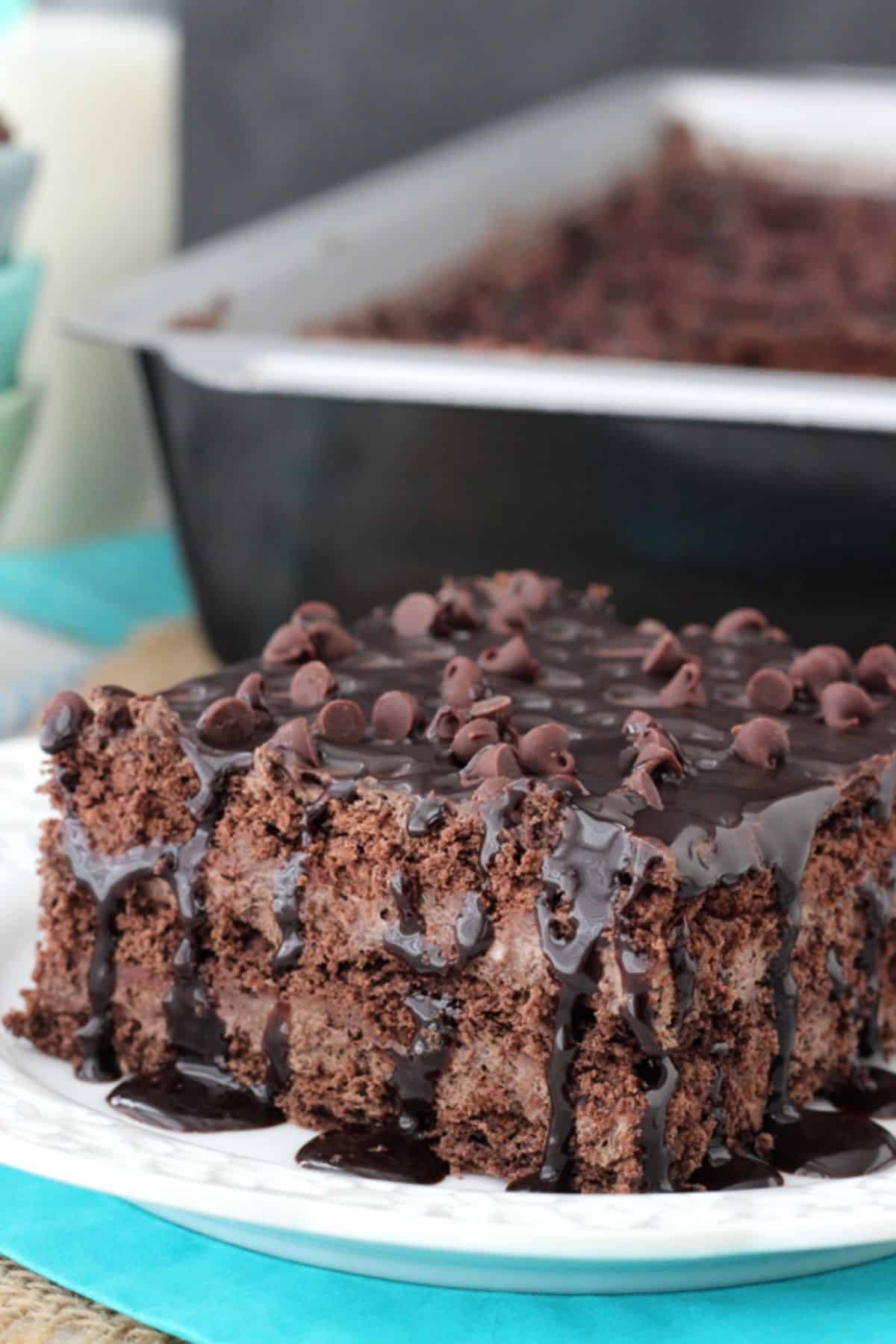 Death by Chocolate Icebox Cake Close up of a slice of death by chocolate icebox cake with the rest of the cake in the background.