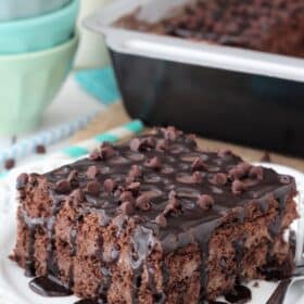 Close up of a slice of death by chocolate icebox cake with the rest of the cake in the background.