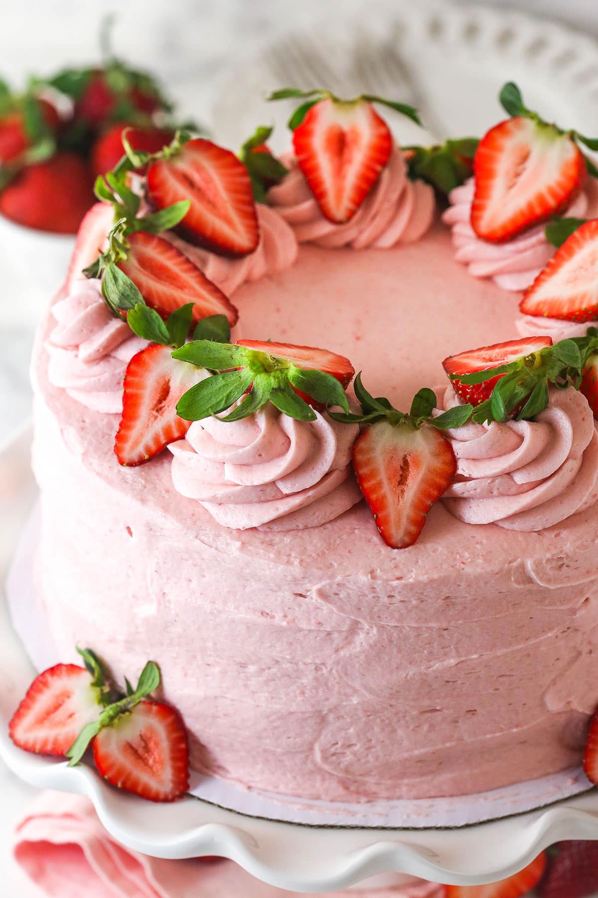 Angled overhead view of a fresh strawberry cake decorated with strawberry slices