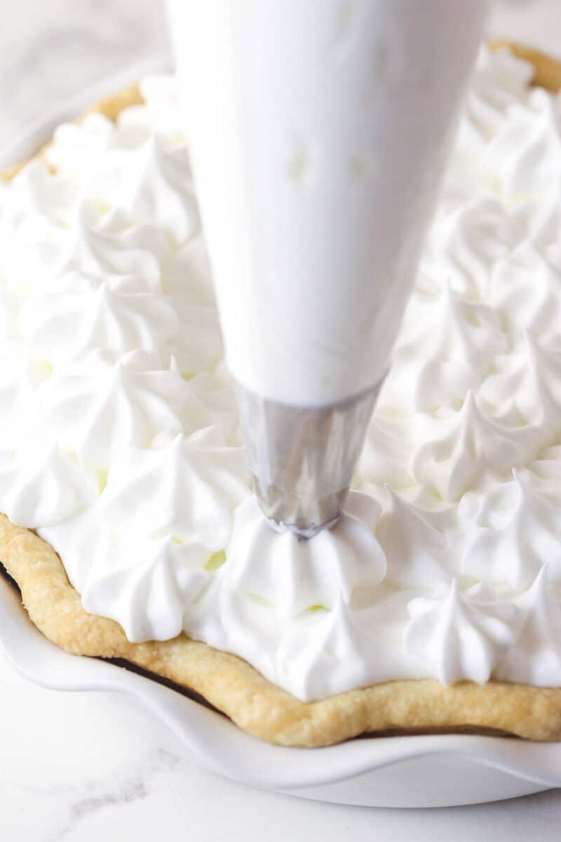This classic lemon meringue pie features a tart lemon filling in a buttery crust topped with a light but stable meringue. Piping meringue onto a pie