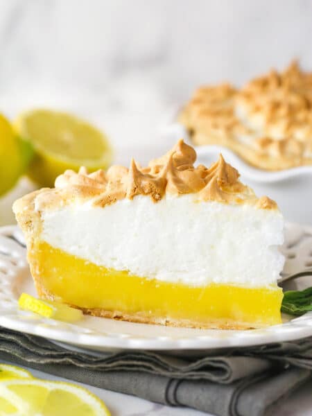 Side view of a slice of lemon meringue pie on a plate