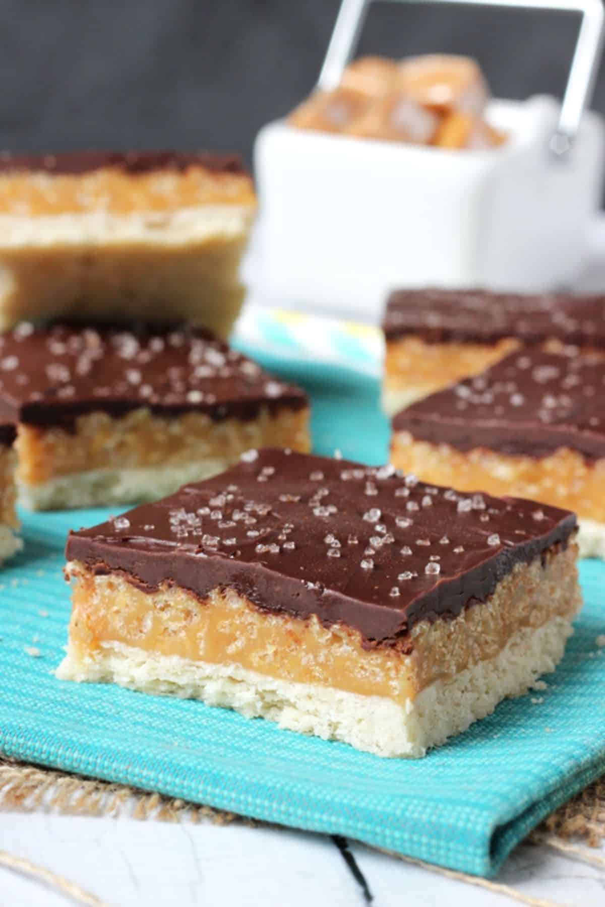 Close up of a caramel shortbread bar with more bars in the background.