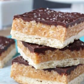 Close up of three caramel shortbread bars on a teal napkin.