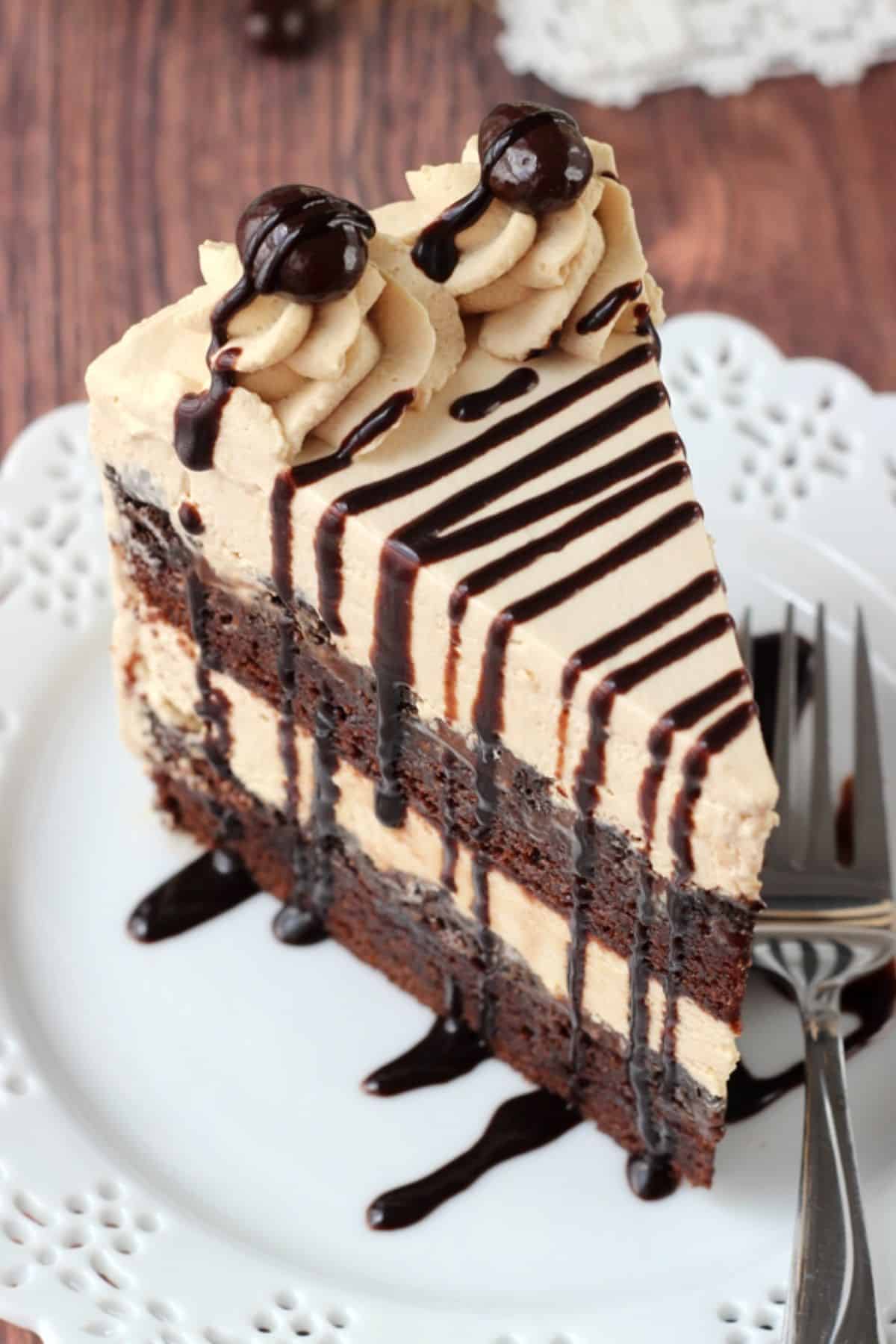 Overhead view of a slice of mocha brownie ice cream cake on a small white plate.