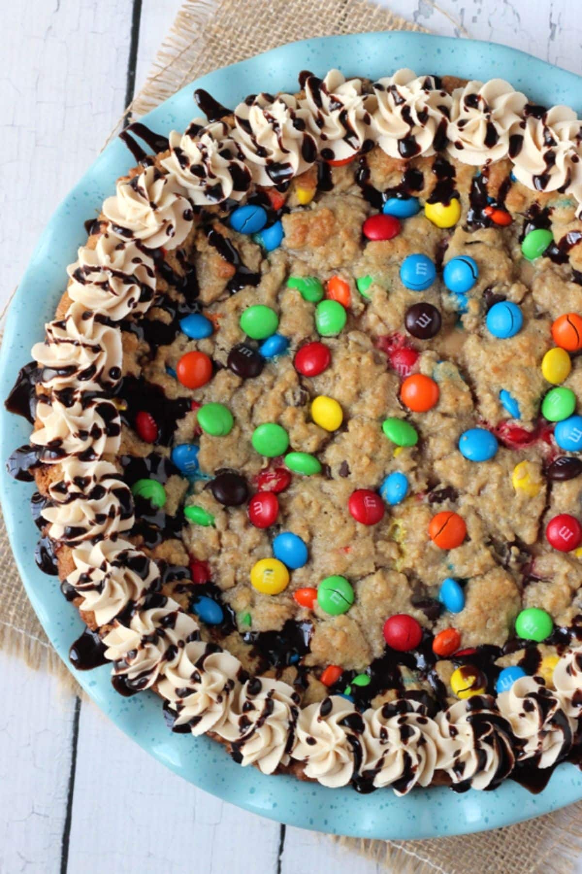 Top view of a decorated monster cookie cheesecake pie in a blue pie plate.