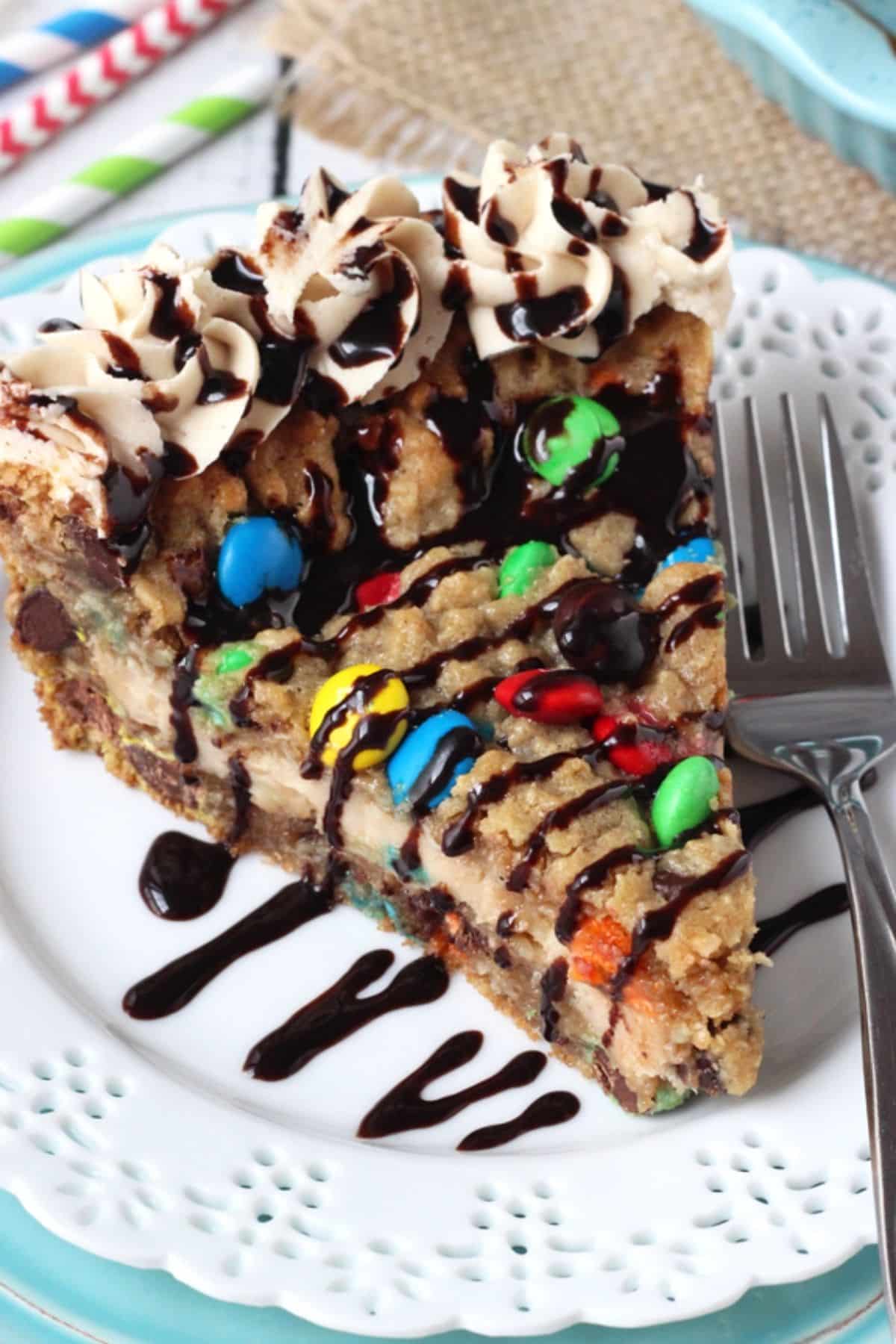 Close up of a slice of monster cookie cheesecake pie on a small white plate.