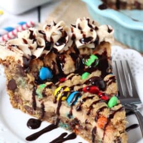 A slice of monster cookie cheesecake pie on a small white plate.