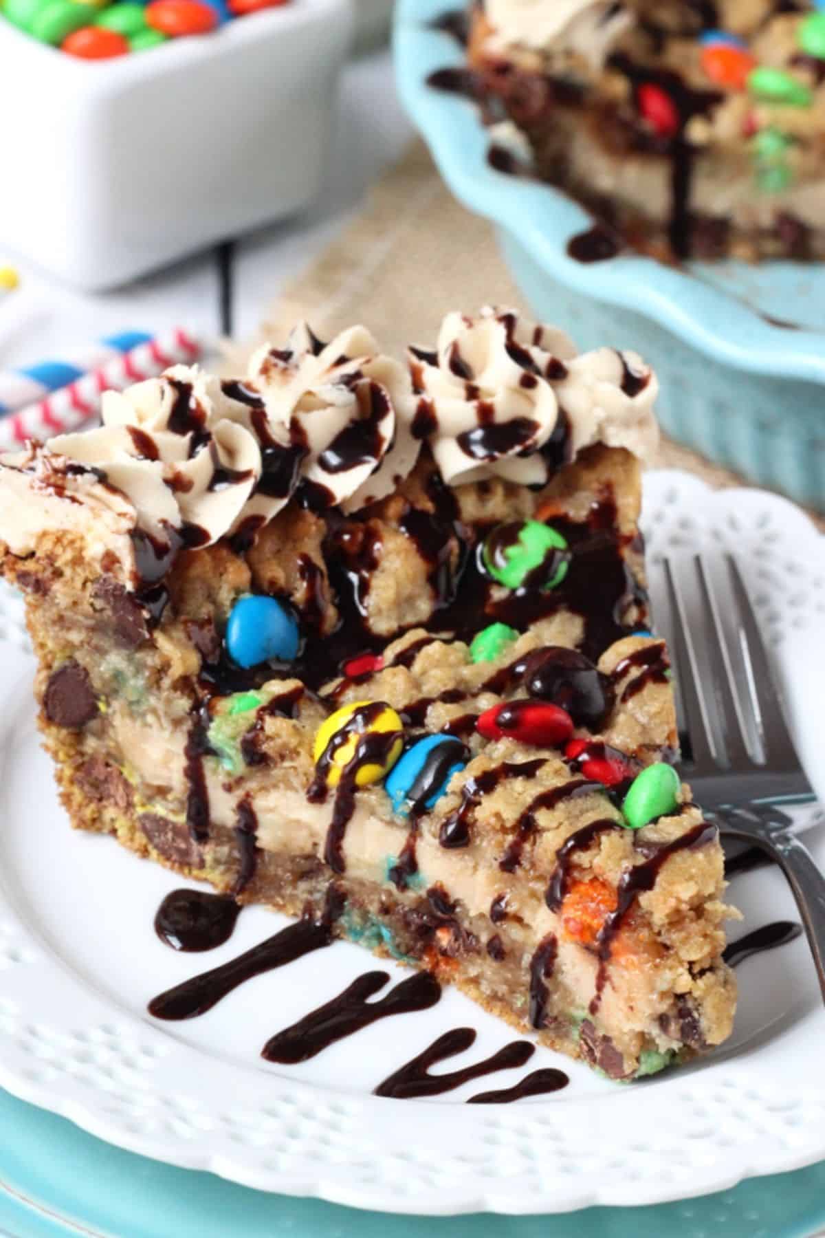 A slice of monster cookie cheesecake pie on a small white plate.
