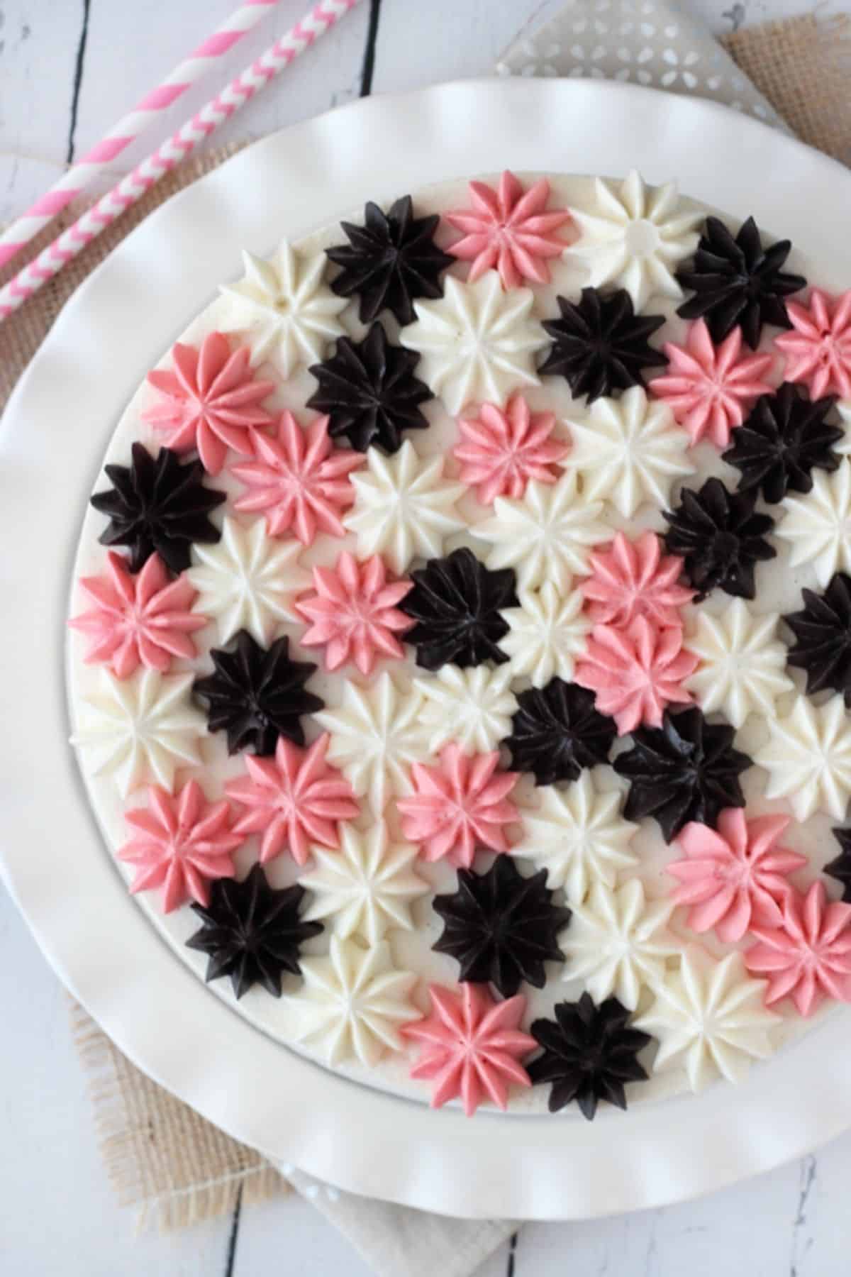 The top of a neapolitan millionaire cake decorated with rosettes.