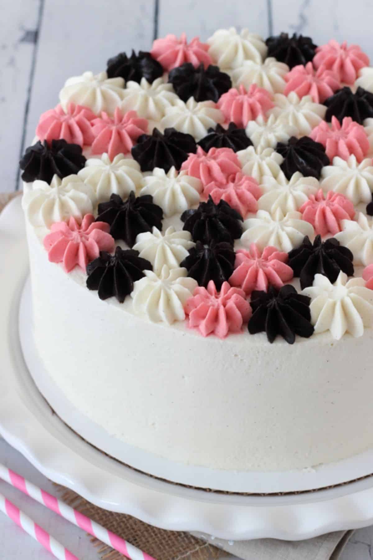 Close up of a neapolitan millionaire cake on a white cake stand.