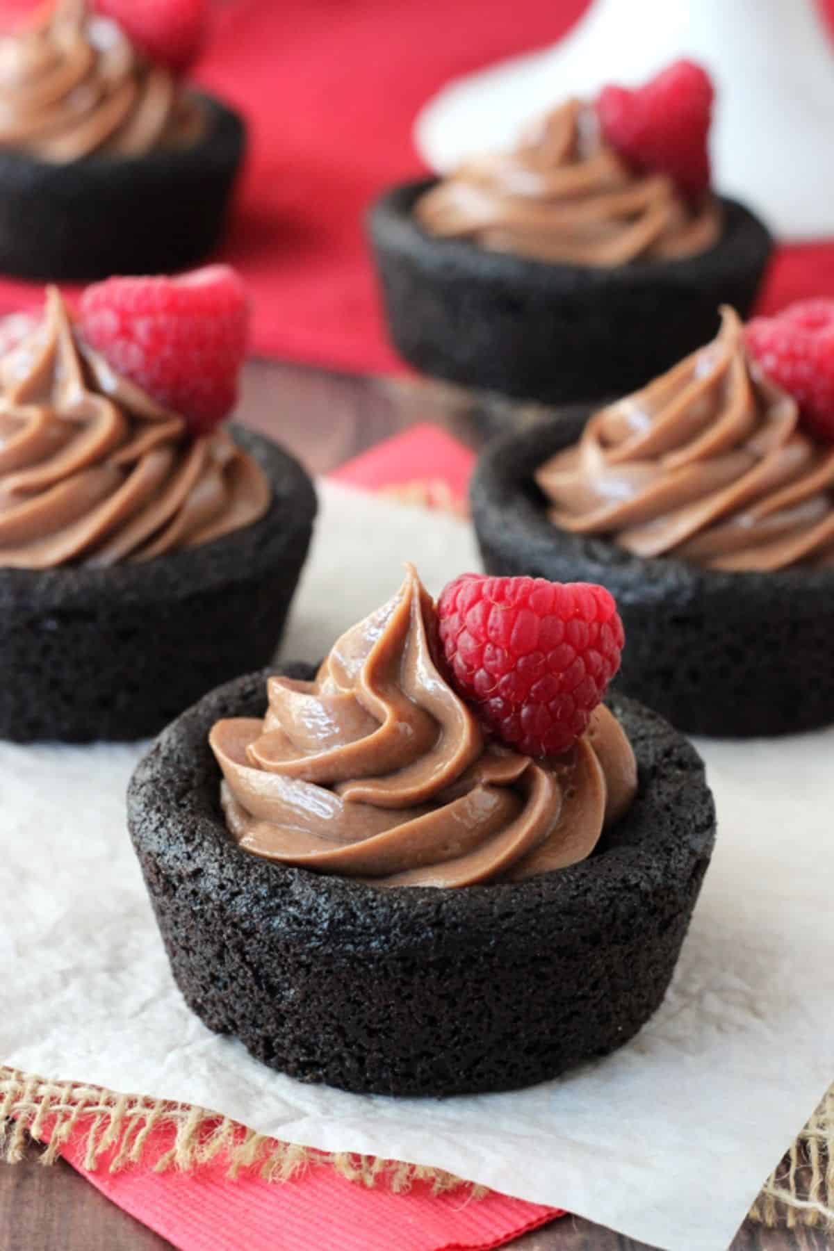Close up of a Nutella cheesecake chocolate cookie cup with more cups in the background.