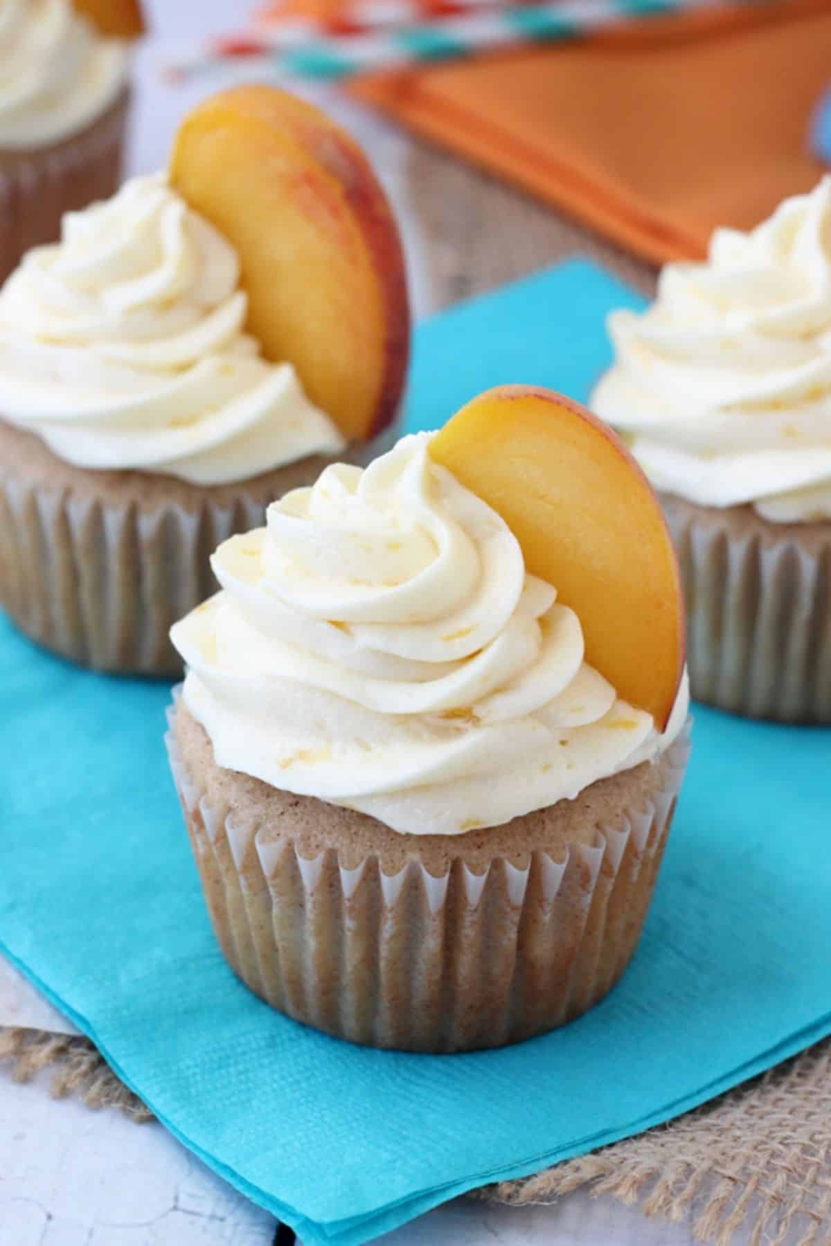 Close up of a peach pie cupcake on a teal napkin.