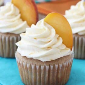 Close up of a peach pie cupcake on a teal napkin.