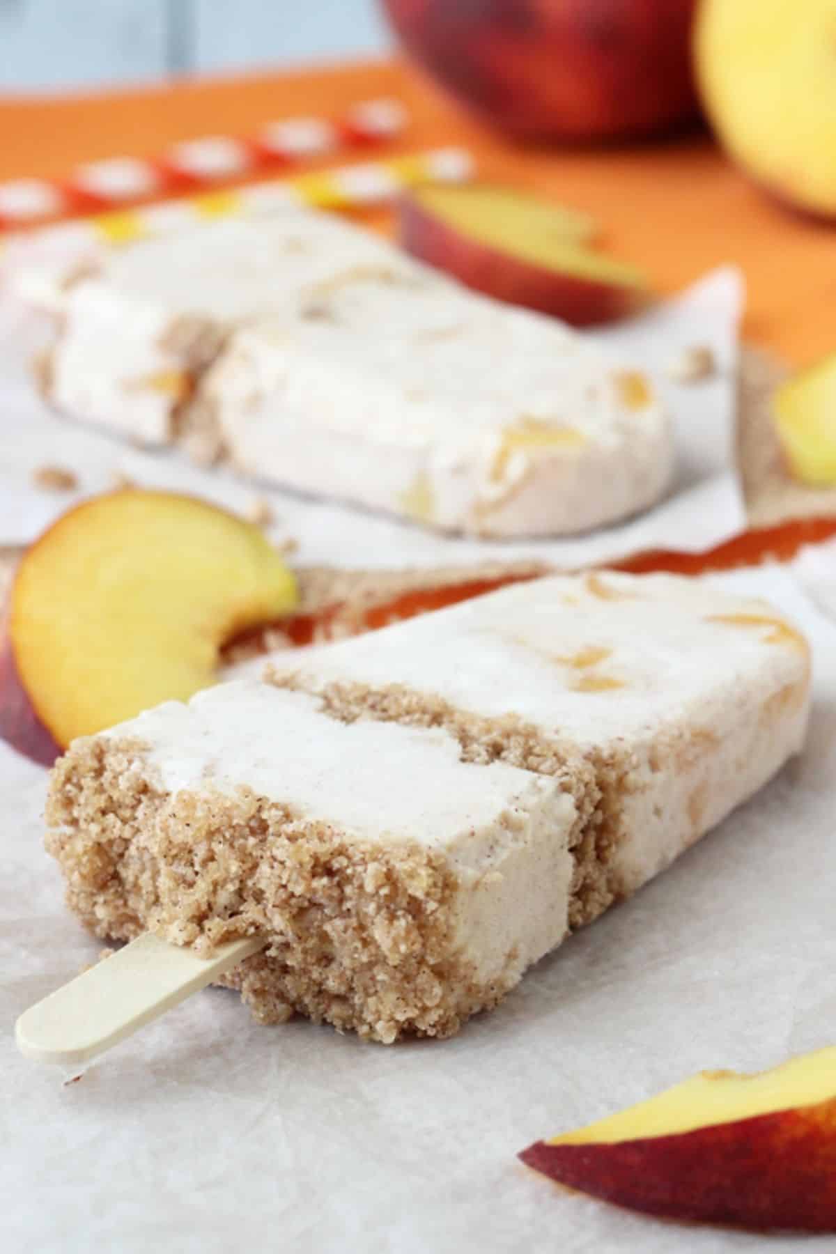 The end of a peach streusel popsicle laying on a piece of parchment.