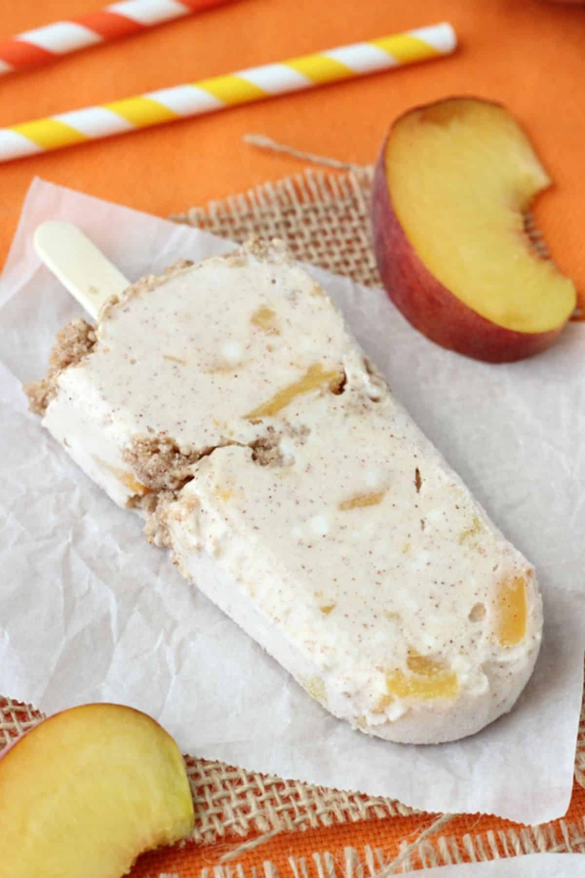 A peach streusel popsicle laying on a piece of parchment.
