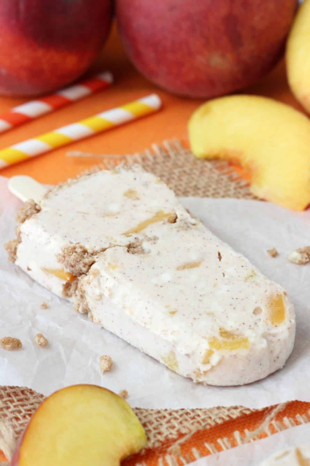 A peach streusel popsicle laying on a piece of parchment.