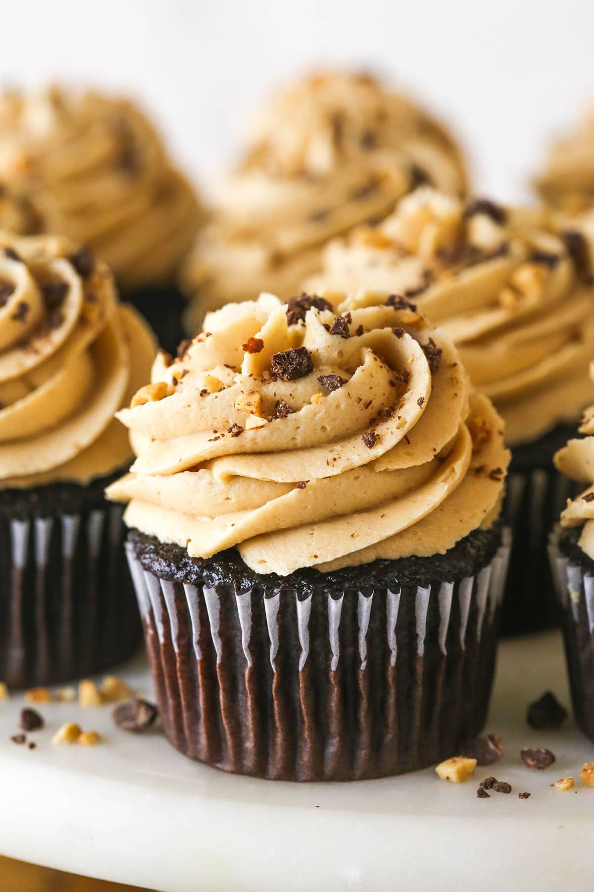 These peanut butter chocolate cupcakes are all about the classic flavor combo, with peanut butter buttercream on moist cupcakes. Close up of peanut butter chocolate cupcakes
