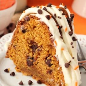 Close up of a slice of pumpkin chocolate chip bundt cake on a small white plate.