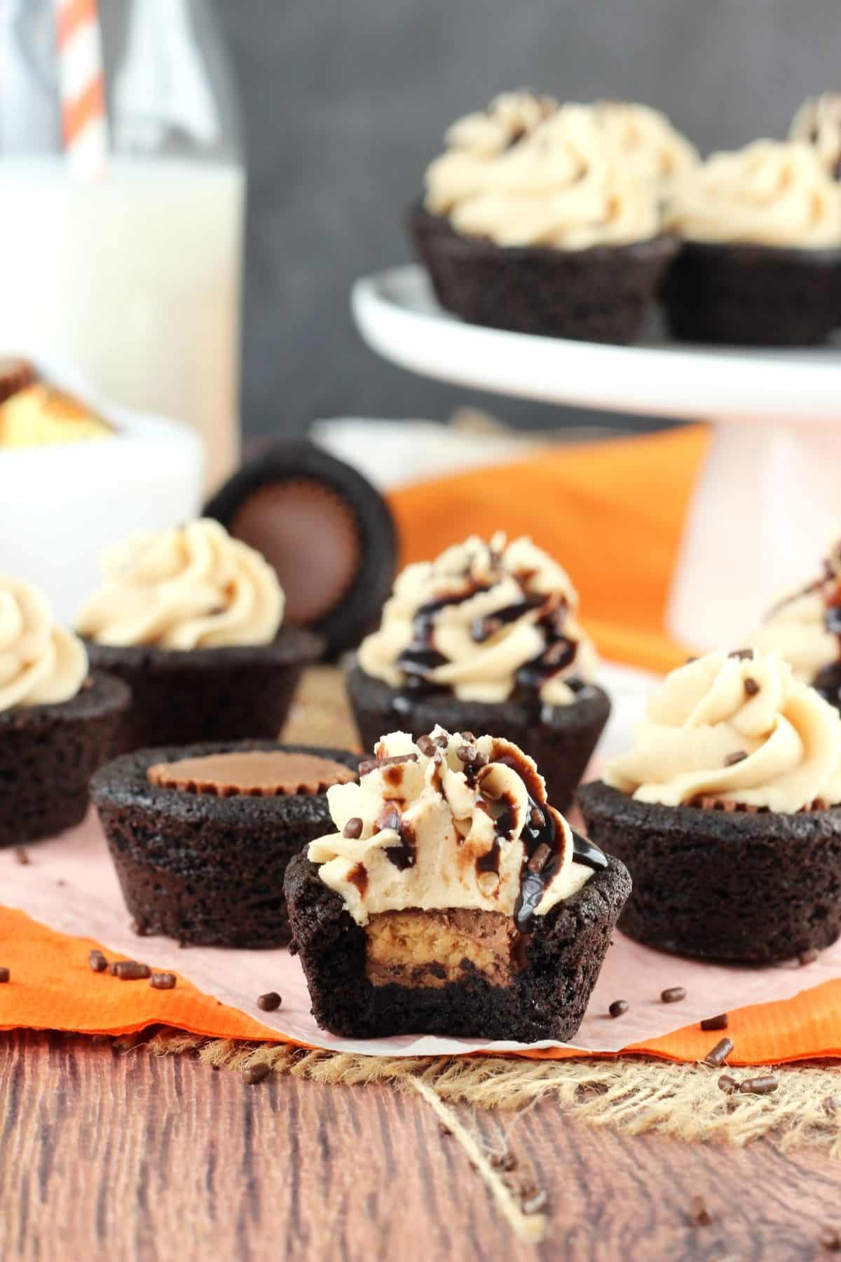 A Reese's chocolate cookie cup with a bite taken out of it with more cookie cups surrounding it.