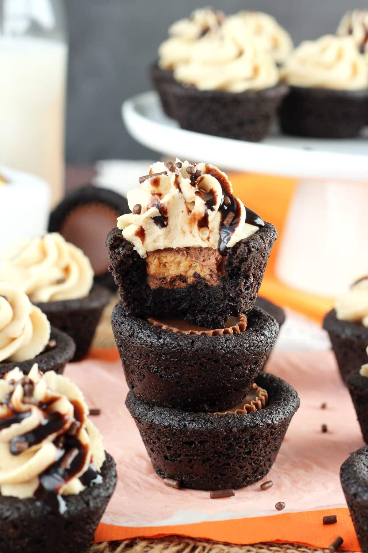 A stack of 3 Reese's chocolate cookie cups with a bite taken out of the top cookie.
