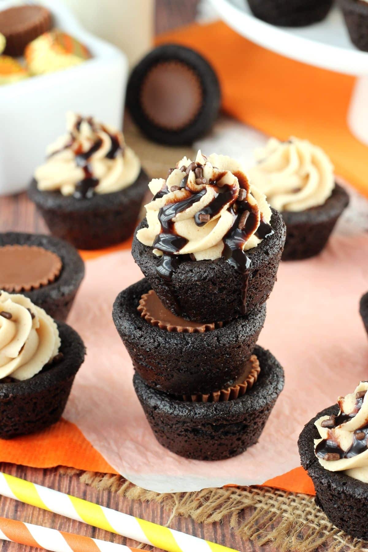 Close up of a stack of 3 Reese's chocolate cookie cups on a piece of parchment paper.