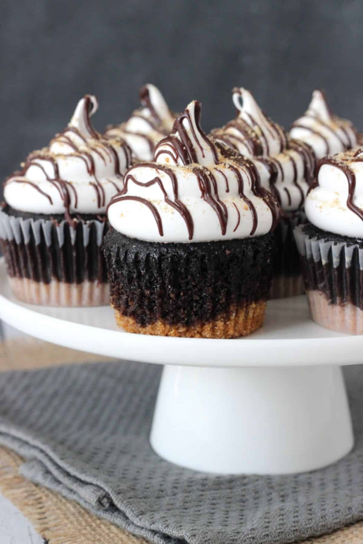 S'mores Cupcakes on a white cake stand.