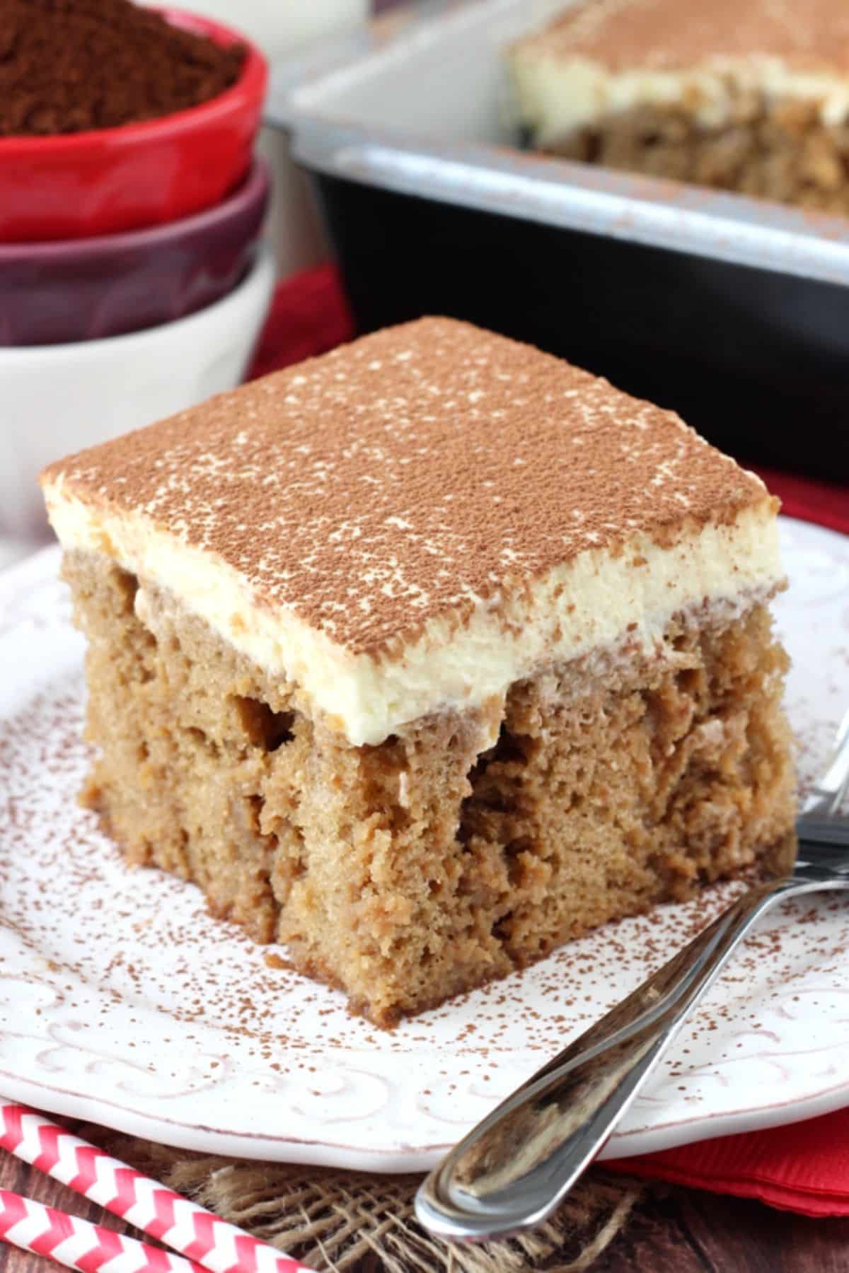 A slice of tiramisu poke cake on a small white plate.