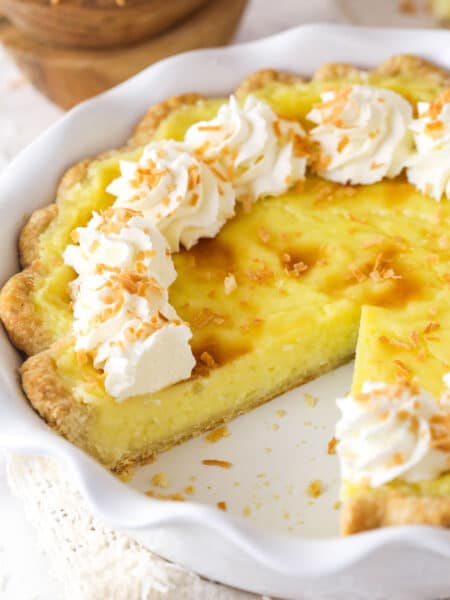 A coconut custard pie with a slice missing