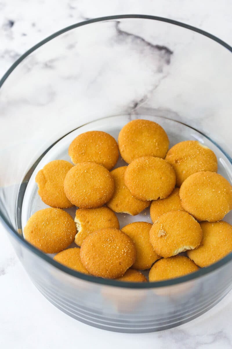 This copycat Magnolia Bakery Banana Pudding is made completely from scratch and mirrors the texture and flavors of the original. Nilla wafers in the bottom of a glass bowl