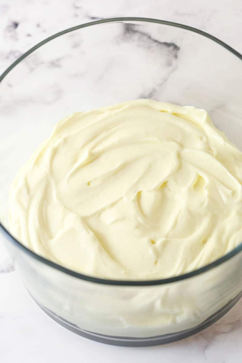 This copycat Magnolia Bakery Banana Pudding is made completely from scratch and mirrors the texture and flavors of the original. Whipped cream pudding mixture spread on top of bananas in a glass bowl