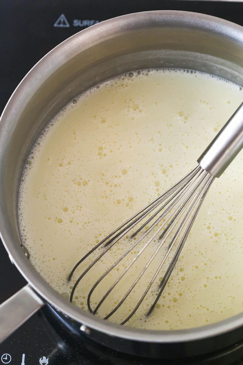 This copycat Magnolia Bakery Banana Pudding is made completely from scratch and mirrors the texture and flavors of the original. Whisking milk and sweetened condensed milk over heat