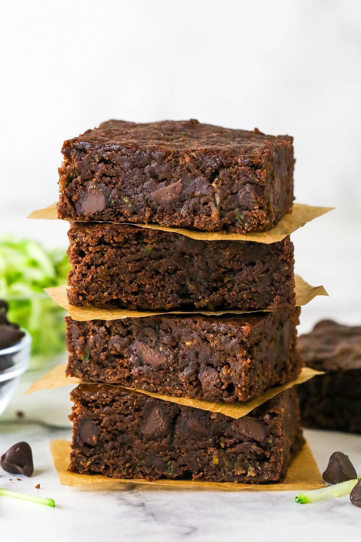 These zucchini brownies are not only quick and easy to make, they have the perfect super dense and fudgy texture. Four zucchini brownies stacked on each other