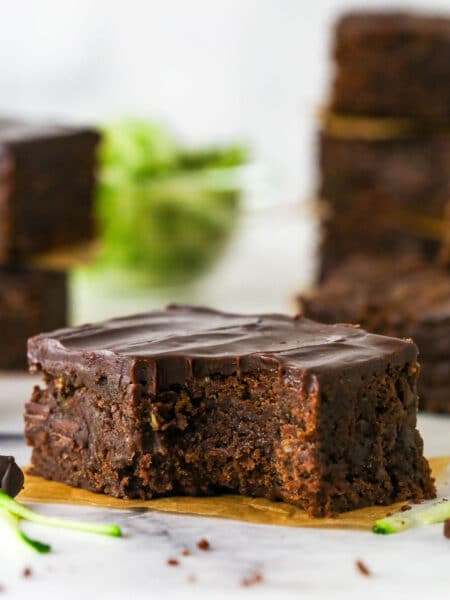 A fudgy zucchini brownie with a bite missing on a yellow napkin