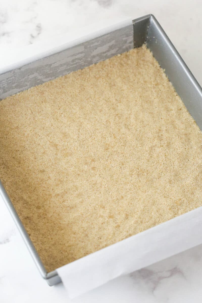 Apple pie bars offer all of the flavor of apple pie in a simple, easy-to-make bar, with shortbread crust, spiced apples, and crumble topping. Unbaked shortbread crust in a square pan