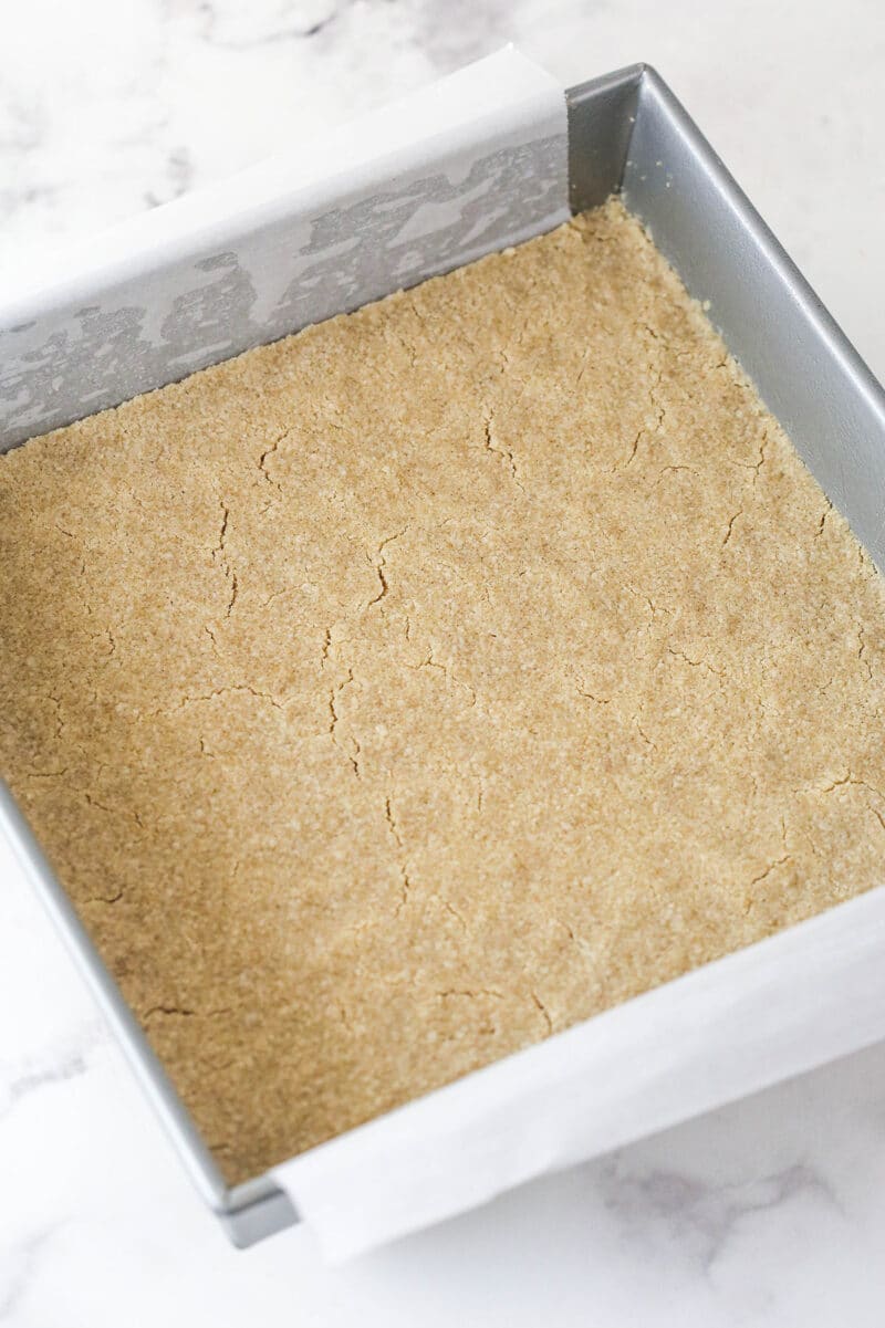 Apple pie bars offer all of the flavor of apple pie in a simple, easy-to-make bar, with shortbread crust, spiced apples, and crumble topping. Baked shortbread crust in a square pan