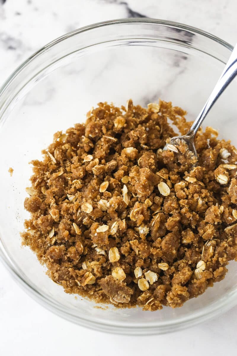 Apple pie bars offer all of the flavor of apple pie in a simple, easy-to-make bar, with shortbread crust, spiced apples, and crumble topping. Brown sugar, oats, and melted butter in a bowl