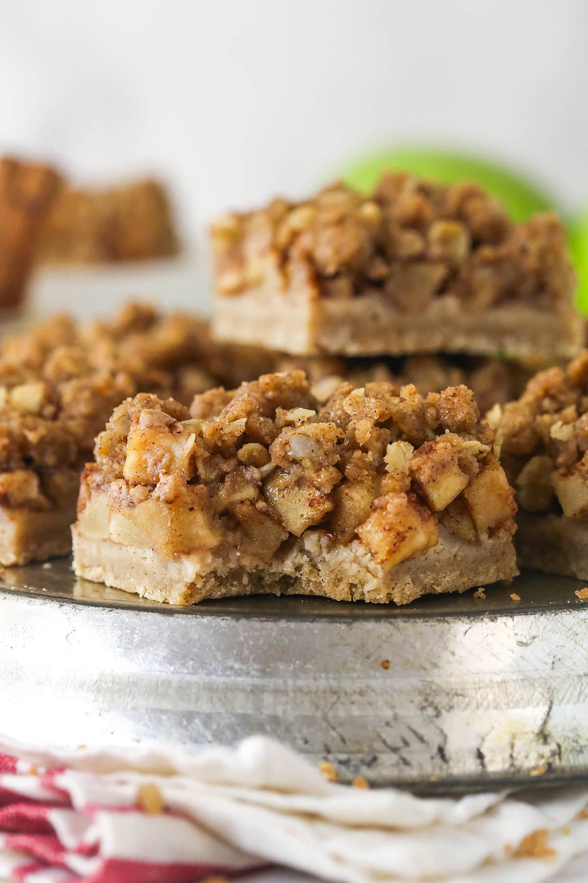 Apple pie bars offer all of the flavor of apple pie in a simple, easy-to-make bar, with shortbread crust, spiced apples, and crumble topping. A plate of apple pie bars, one with a bite missing