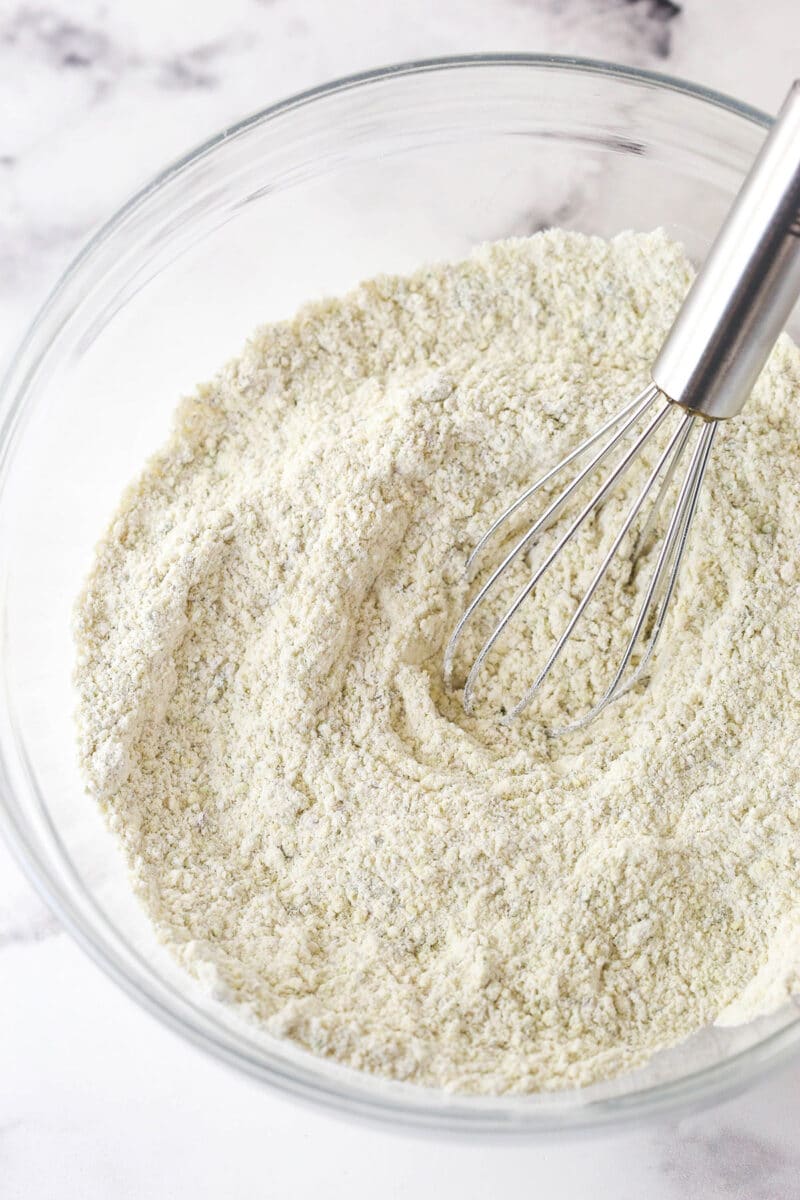 These pistachio cupcakes are full of real pistachios in the cupcakes and the buttercream, giving them their beautiful color and nutty flavor. Whisking dry ingredients in a bowl