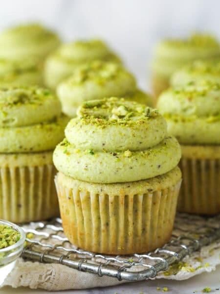 Front view of pistachio cupcakes on a wire cooling rack