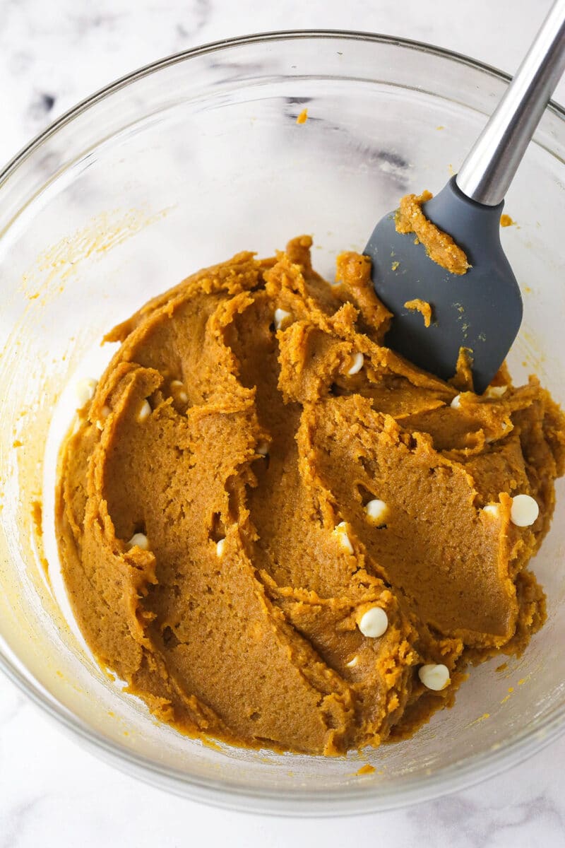 Folding white chocolate chips into pumpkin blondie batter