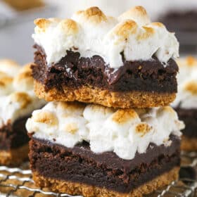 Two s'mores brownies stacked on each other, the top one with a bite missing
