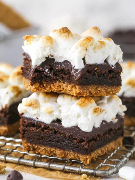 Two s'mores brownies stacked on each other, the top one with a bite missing